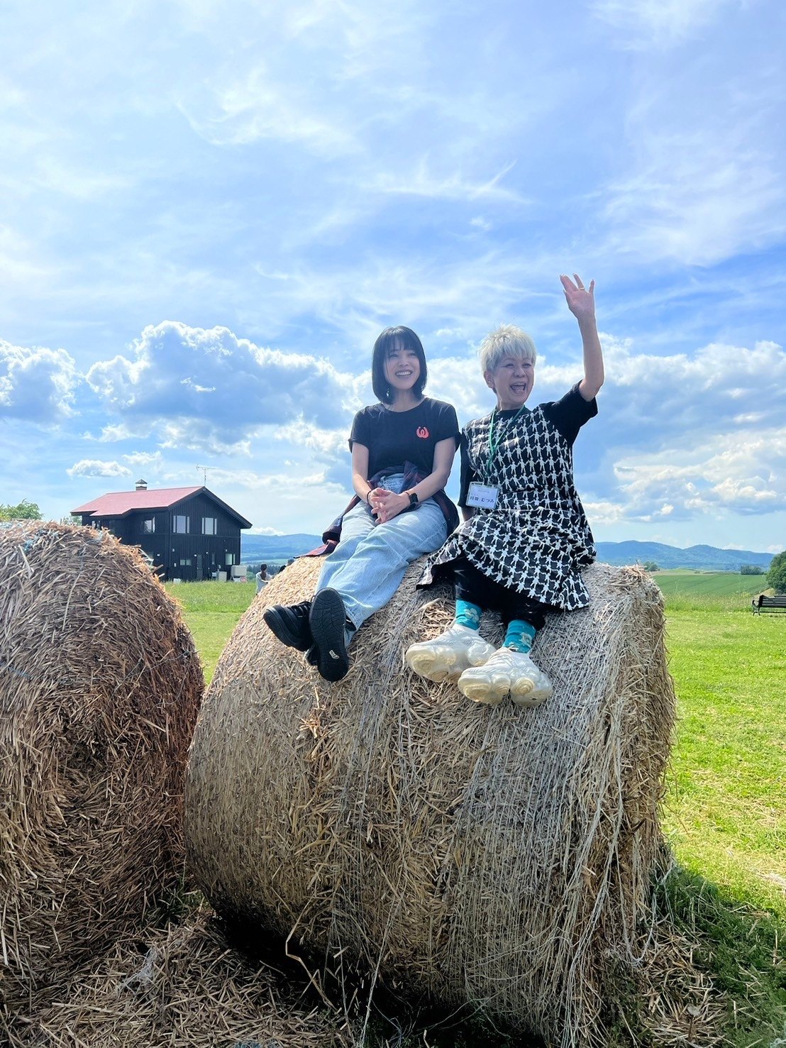 Hokkaido study tour (2024) — participants on hay bales under a blue sky